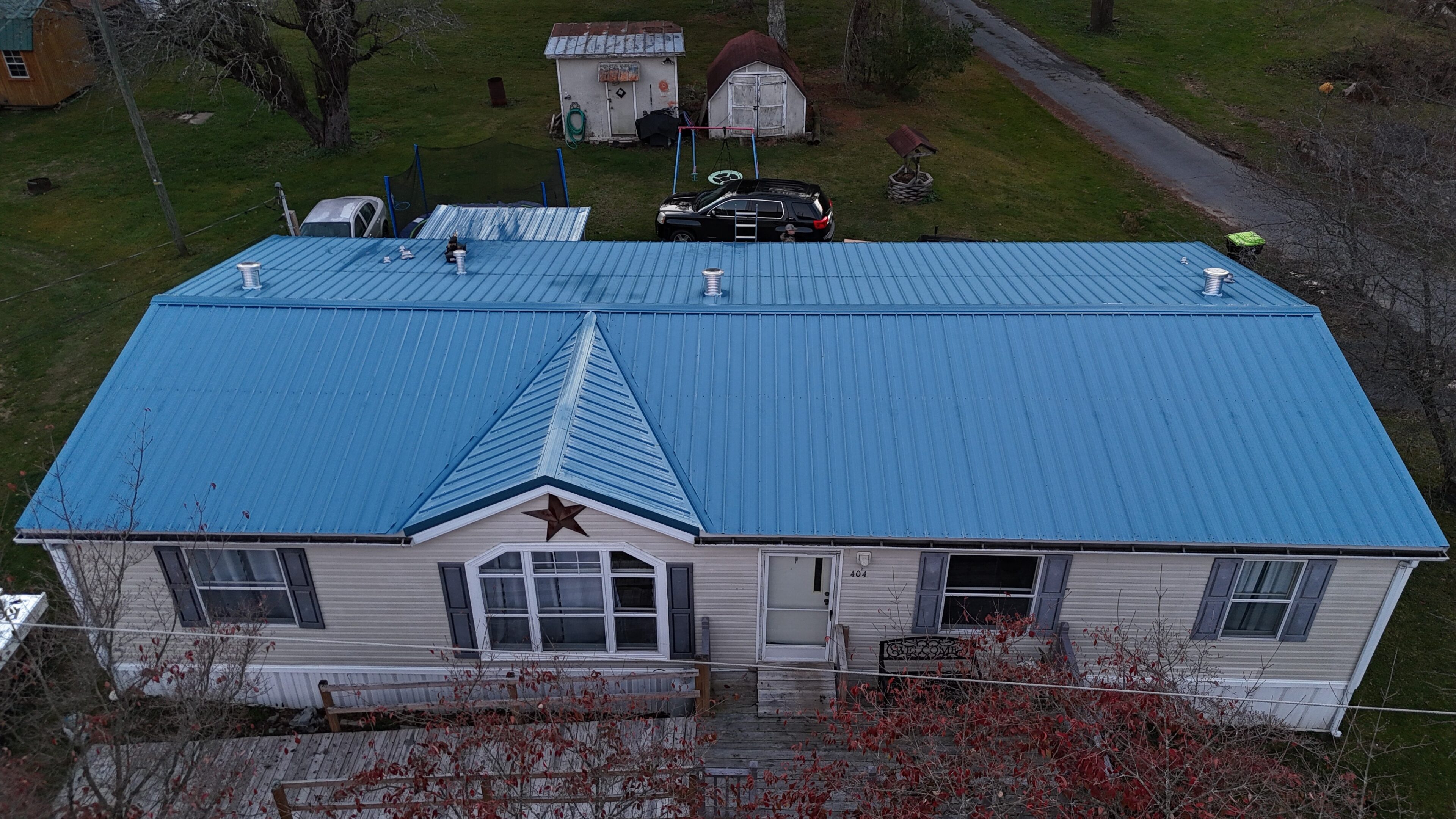 A house with a blue metal roof viewed from above.