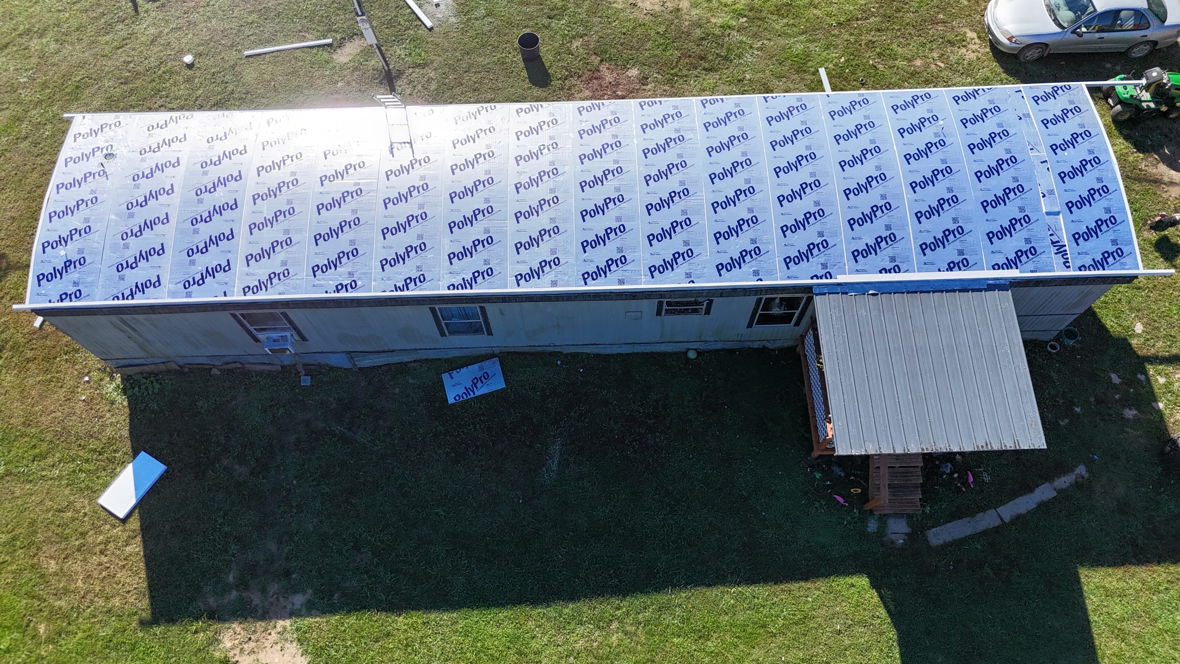 A shipping container modified with a roof and surrounded by a fenced yard.