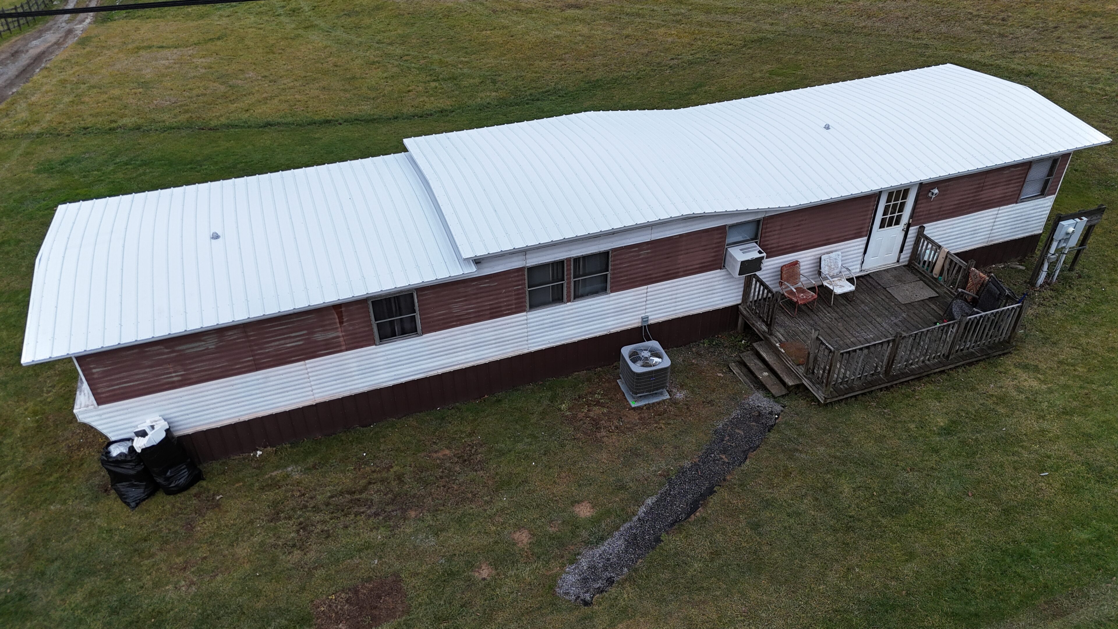 A long, single-story building with a white roof and brown siding.
