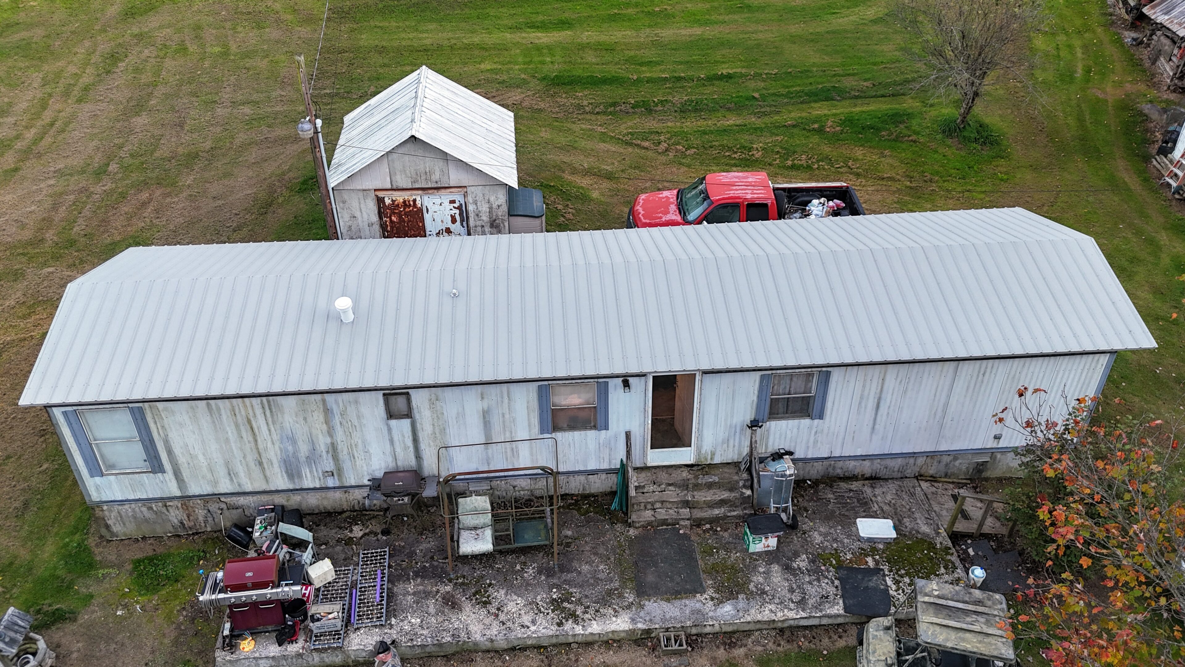 Aerial view of a rural property with trailers, vehicles, and a shed.