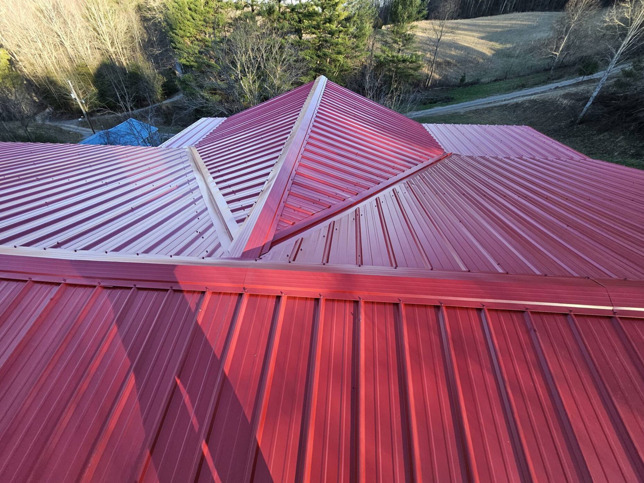 A red metal roof with a pyramid hip design.