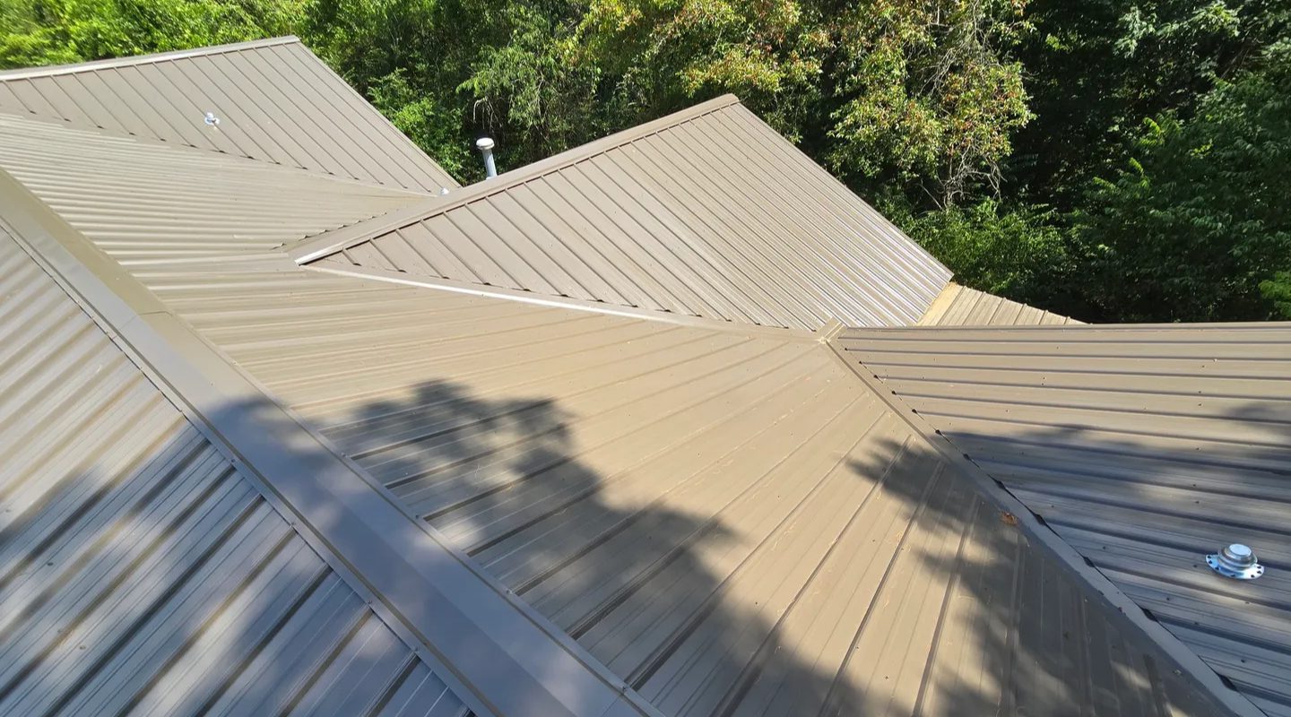 Metal roofs with multiple angles and trees in the background.